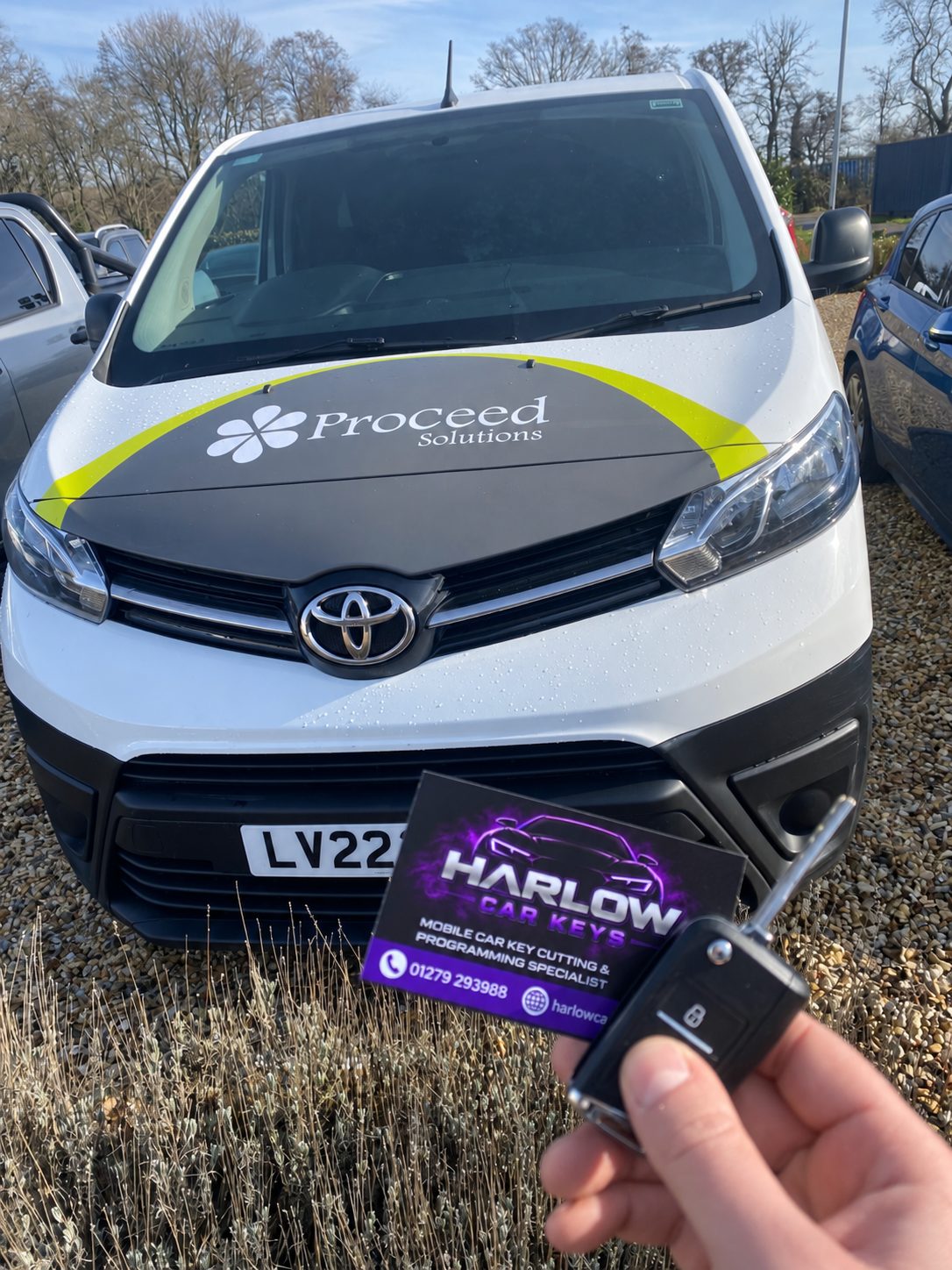New key supplied for a 2022 Toyota Proace van in Ongar after the customer lost their only key, held in front of the van with a Harlow Car Keys business card